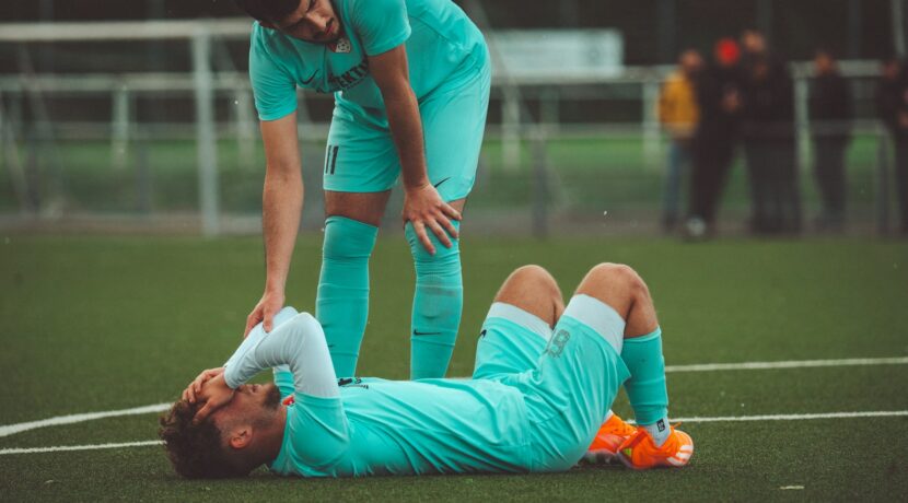 a soccer player is laying on the ground