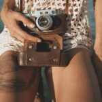 person holding camera near water
