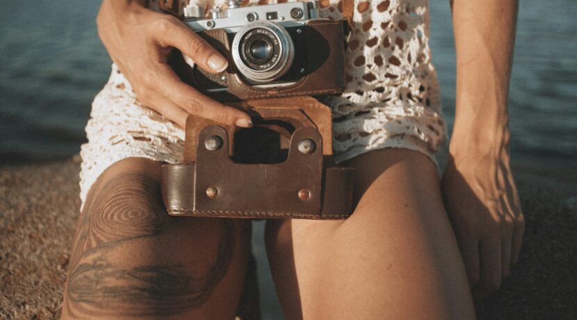 person holding camera near water