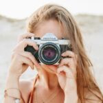 woman taking picture using silver Pentax camera