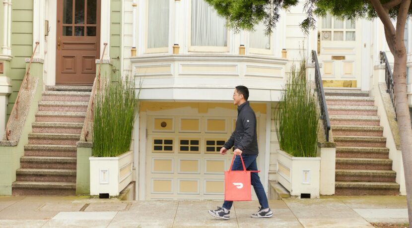 man walking with DoorDash bag