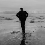 man in black jacket standing on water