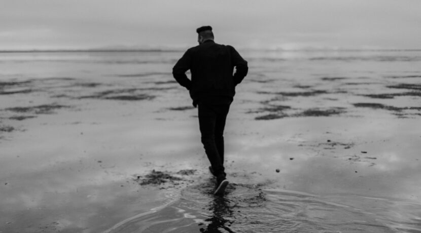 man in black jacket standing on water
