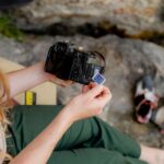 A woman sitting on a chair holding a camera