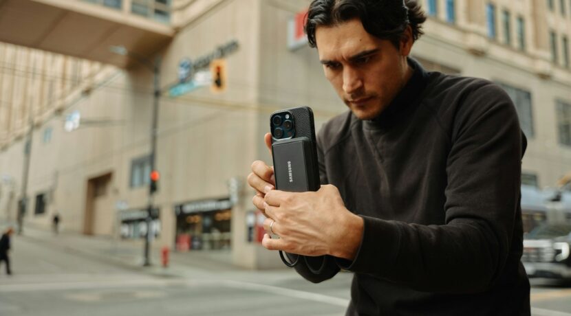 A man standing on the street looking at his cell phone