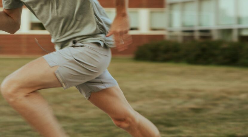 a man in shorts and a t - shirt is playing with a frisbee
