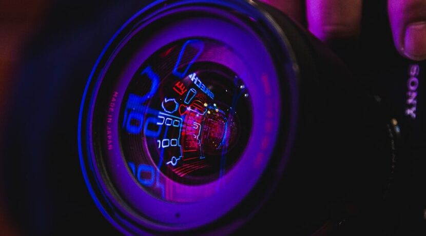 person holding black and blue camera lens