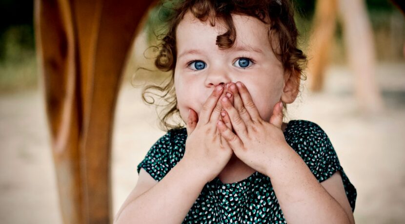 toddler holding her lips